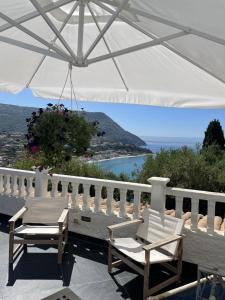 a patio with two chairs and an umbrella at Capovaticano - Unique SEA VIEW - Villa Renaissance in Santa Maria