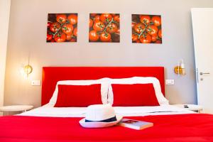 un letto rosso con un cappello e dei libri sopra di ON' MICHELE GUEST HOUSE a Sorrento