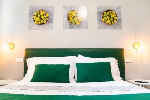 una camera con un letto verde e bianco con quattro quadri sul muro di ON' MICHELE GUEST HOUSE a Sorrento