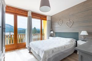 1 dormitorio con cama y ventana grande en Le Repère Des Marmottes, en Xonrupt-Longemer