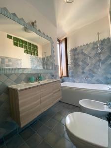 a bathroom with a sink and a toilet and a tub at Casa Balilla in La Maddalena +12 photos