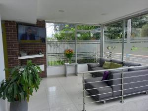sala de estar con 2 sofás y ventanas en Hotel Burana, en Bogotá
