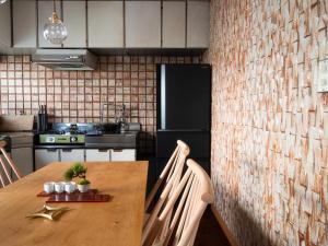 a kitchen with a wooden table and a refrigerator at SUKIYA-zukuri Suehiro in Hida