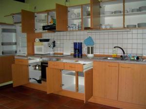 a kitchen with wooden cabinets and a stove top oven at Landhaus mit Weitblick in Holtsee