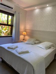 מיטה או מיטות בחדר ב-Suites Prime Itamambuca