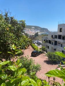 a car parked in a parking lot next to a building at Lovely 2 bedroom with a pool in front of the beach in Sesimbra