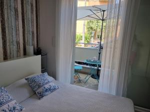 a bedroom with a bed and a balcony with a table at Residenza Azzurra in Cattolica
