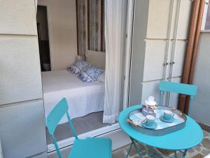 uma pequena varanda com uma mesa e cadeiras e uma cama em Residenza Azzurra em Cattolica