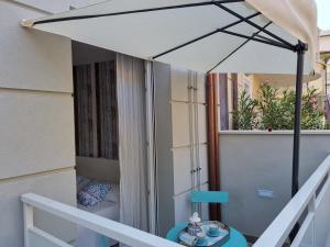 a white umbrella on a balcony with a table at Residenza Azzurra in Cattolica