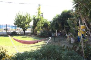 a hammock in a yard with trees and a fence at Odyssia Apartments in Katelios