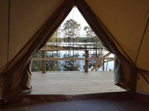 a tent with a view of a lake from the inside at Ruustinnan telttamajoitukset in Saarijärvi