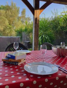 una mesa con un paño de lunares rojo y blanco con copas de vino en La Torre de Piedra - perfect for a family holiday! en Cortes de la Frontera