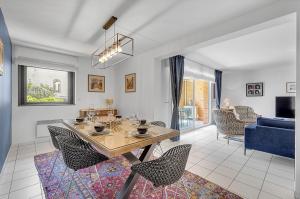 a living room with a table and chairs and a couch at LES JARDINS DE L'OLYMPE - Appartement lumineux de 137m2 in Toulouse