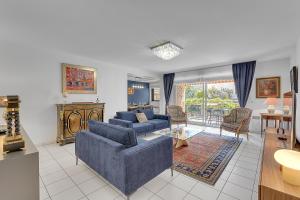 a living room with two blue couches and a table at LES JARDINS DE L'OLYMPE - Appartement lumineux de 137m2 in Toulouse