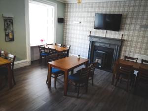 a dining room with tables and chairs and a fireplace at George and Abbotsford in Melrose