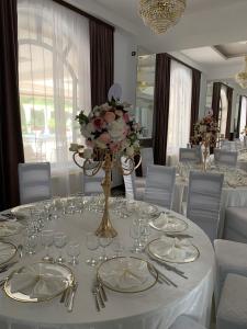 a dining room with a white table with glasses and flowers at Laura Holiday in Brăila +39 photos