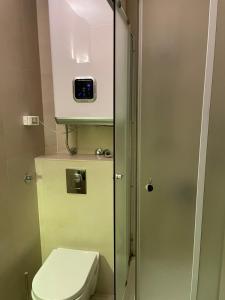 ein Badezimmer mit einem WC und einer Uhr an der Wand in der Unterkunft Vila NADJA in Kopaonik