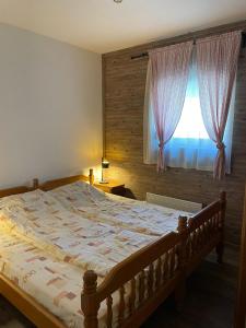 ein Schlafzimmer mit einem großen Bett mit Fenster in der Unterkunft Vila NADJA in Kopaonik