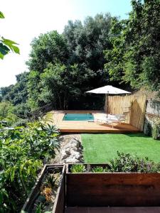 a backyard with a swimming pool and an umbrella at Flat with panoramic terrace and private pool mt5x3 in Taormina