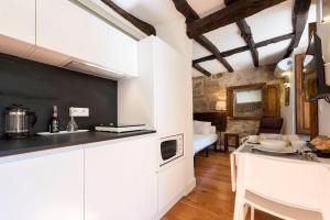 een keuken met witte kasten en een woonkamer bij Casa da Muralha in Porto