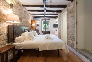 a bedroom with a large bed with a teddy bear on it at Casa da Muralha in Porto