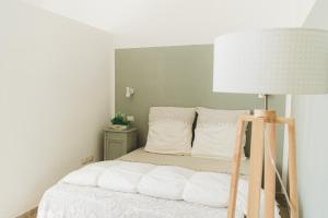 una camera da letto con un letto con una lampada e cuscini di Masseria Triticum a Francavilla Fontana