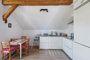een keuken met witte kasten en een tafel bij Apartament Via Regia in Krościenko