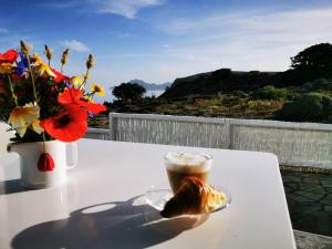 uma chávena de café e um bolo numa mesa com flores em Avra Pahainas em Pachaina