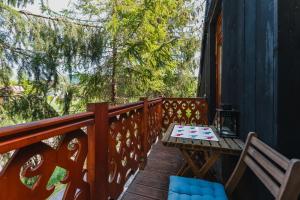 un balcón de madera con mesa y sillas. en Apartament Via Regia en Krościenko