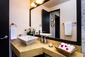 een badkamer met een wastafel en een grote spiegel bij Coromuel Condo in Cabo San Lucas +6 foto's