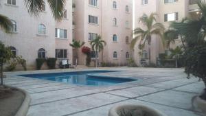 een zwembad voor een gebouw bij Coromuel Condo in Cabo San Lucas