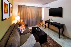 een woonkamer met een bank en een flatscreen-tv bij Coromuel Condo in Cabo San Lucas