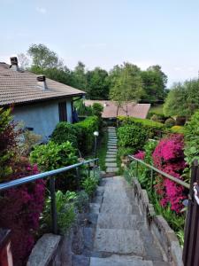 un sentiero in pietra che conduce a un giardino con fiori rosa di Maison Al Nocino a Stresa