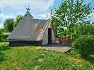 een tent met een tafel en een houten terras bij Resort & Camping - Val de Braye in Bessé-sur-Braye