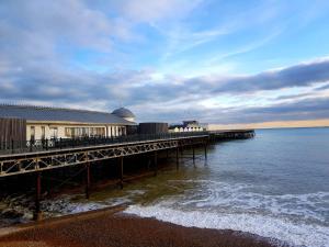 a pier with a building on the water at Beautiful Apartment 2 mins To The Beach in St. Leonards