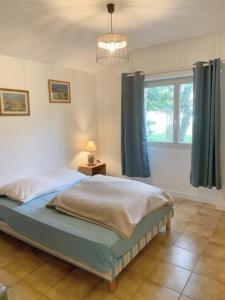een slaapkamer met een bed en een raam bij Logement de charme calme assuré in Rieux