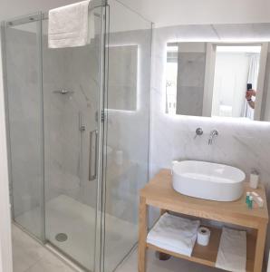 a bathroom with a glass shower and a sink at Younique in Sorrento