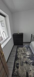 a bedroom with a bed and a dresser and a window at ANDI 2-apartament in Băile Herculane