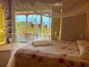 Schlafzimmer mit einem Bett und Blick auf einen Balkon in der Unterkunft Villa Caribbean Dream in Vieux Fort