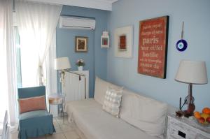 salon z białą kanapą i niebieskimi ścianami w obiekcie Cosy Home w mieście Perea