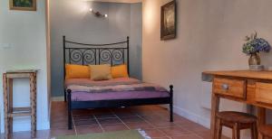 1 dormitorio con 1 cama con almohadas de color naranja y morado en Casa Ribeira, en Coentral das Barreiras