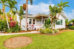 a white house with palm trees in a yard at Siesta Key Island Rentals in Siesta Key +211 photos