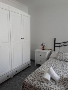 a bedroom with white cabinets and a bed with two towels at Piso Tarayuela in Barbate