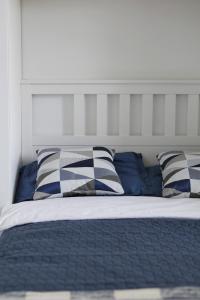 a bed with blue and white pillows on it at Capital Towers - Apartament Modern z widokiem na rzekę in Rzeszów