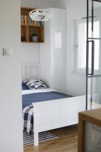um pequeno quarto branco com uma cama e uma janela em Capital Towers - Apartament Modern z widokiem na rzekę em Rzeszów