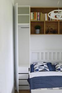 a bedroom with a bed and a book shelf at Capital Towers - Apartament Modern z widokiem na rzekę in Rzeszów