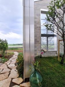 a glass vase with flowers in it next to a building at Anonima Agricola in Orbetello