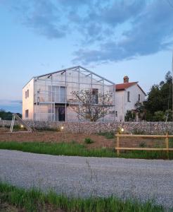 une maison en verre sur le côté d'une route dans l'établissement Anonima Agricola, à Orbetello