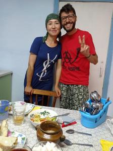 a man and a woman standing in front of a table at Mountain Horse Trekking Guesthouse in Karakol