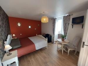 1 dormitorio con cama, mesa y TV en Les Petits Jardins de Cissé Chambre de Charme en Cissé